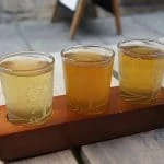 Trois verres de bière assis sur une table en bois.