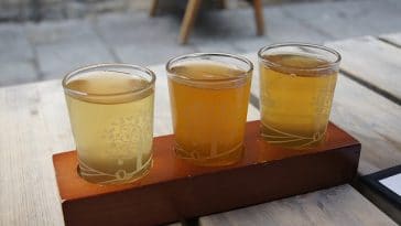 Trois verres de bière assis sur une table en bois.