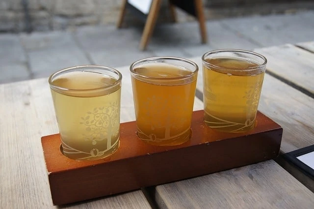 Trois verres de bière assis sur une table en bois.
