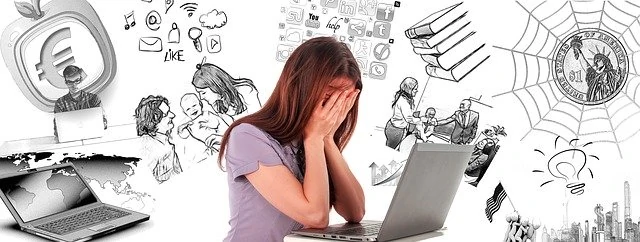 Une femme est assise devant un ordinateur portable avec de nombreux dessins dessus.