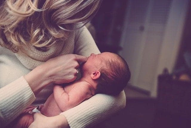 Une femme tient un bébé dans ses bras.