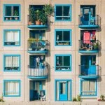 Un immeuble bleu avec balcons et plantes.