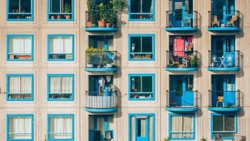 Un immeuble bleu avec balcons et plantes.