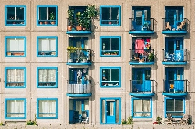 Un immeuble bleu avec balcons et plantes.