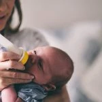 Une femme nourrit un bébé avec un biberon.