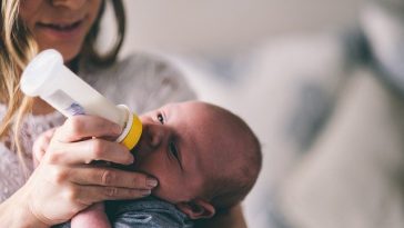 Une femme nourrit un bébé avec un biberon.