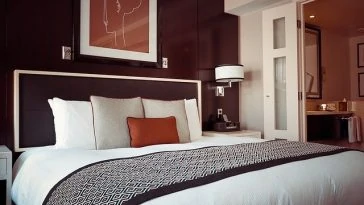 Un lit dans une chambre d’hôtel aux accents marron et orange.