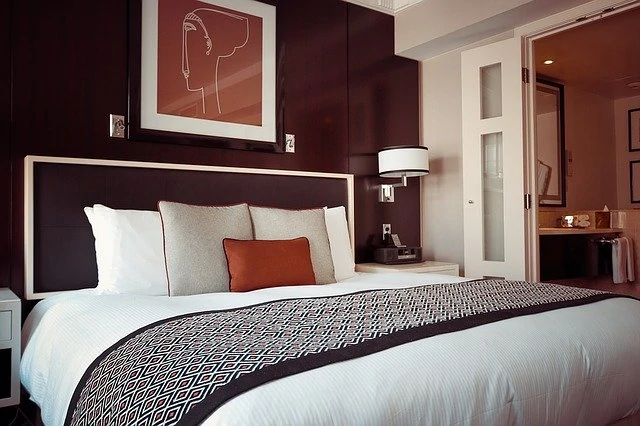 Un lit dans une chambre d’hôtel aux accents marron et orange.