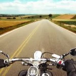 Une vue d’une moto roulant sur une route de campagne.