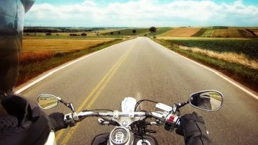 Une vue d’une moto roulant sur une route de campagne.