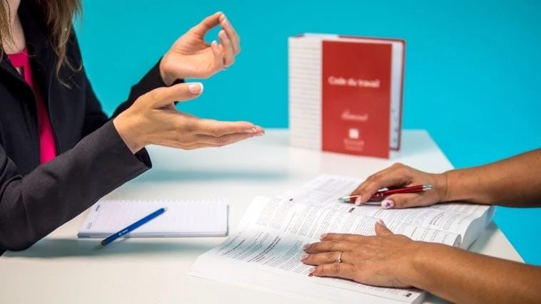 Deux femmes assises à une table et se parlant.