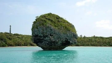 Une formation rocheuse au milieu d’un plan d’eau.