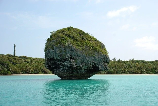 Une formation rocheuse au milieu d’un plan d’eau.