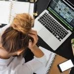 Une femme est assise à un bureau avec un ordinateur portable.