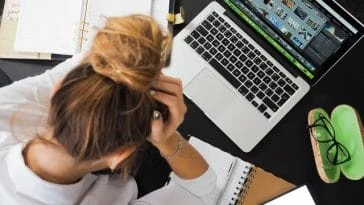 Une femme est assise à un bureau avec un ordinateur portable.