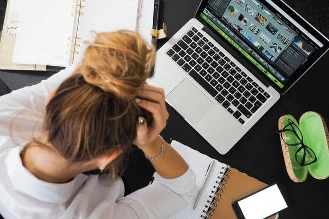 Une femme est assise à un bureau avec un ordinateur portable.