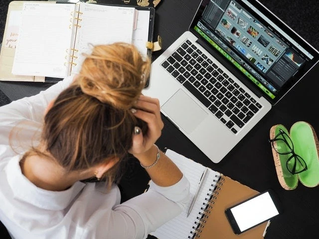 Une femme est assise à un bureau avec un ordinateur portable.