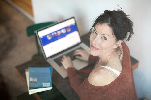 Une femme assise devant un ordinateur portable.