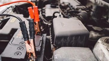 Une batterie de voiture se trouve dans le capot d’une voiture.