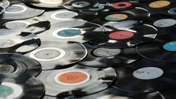 De nombreux disques vinyles traînent par terre.