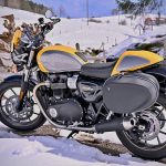 Une moto jaune et noire garée dans la neige.