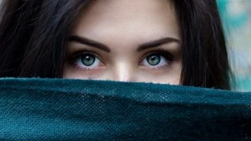 Une femme aux yeux verts qui sort d’un foulard.