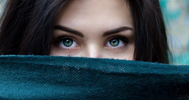 Une femme aux yeux verts qui sort d’un foulard.