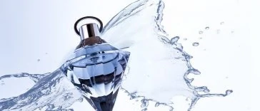 Une bouteille de parfum avec des éclaboussures d'eau.