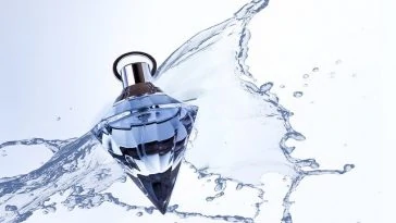 Une bouteille de parfum avec des éclaboussures d'eau.