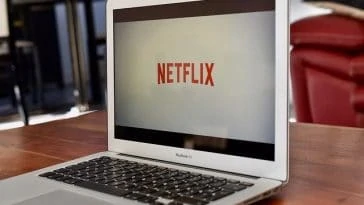 Un ordinateur portable portant le logo Netflix est posé sur une table.
