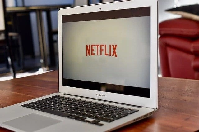 Un ordinateur portable portant le logo Netflix est posé sur une table.