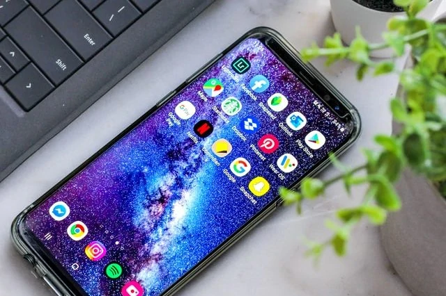 Le Samsung Galaxy S20 est posé sur une table à côté d'un ordinateur portable.