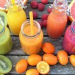 Une variété de jus de fruits sont disposés sur une table en bois.