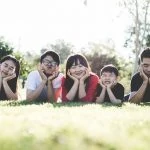 Une famille allongée sur l’herbe dans un parc.