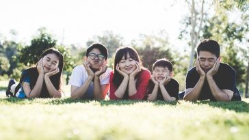 Une famille allongée sur l’herbe dans un parc.