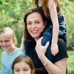 Une femme et ses deux filles posent pour une photo de famille.