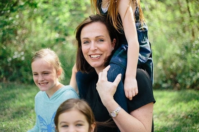 Une femme et ses deux filles posent pour une photo de famille.