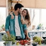 Jeune couple exprimant son amour à travers des surprises pour son homme dans la cuisine.