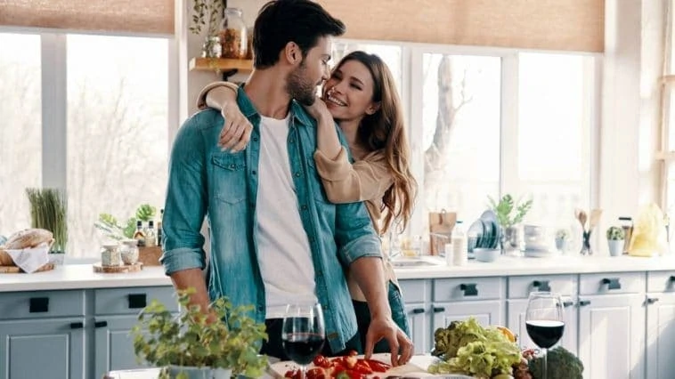 Jeune couple exprimant son amour à travers des surprises pour son homme dans la cuisine.