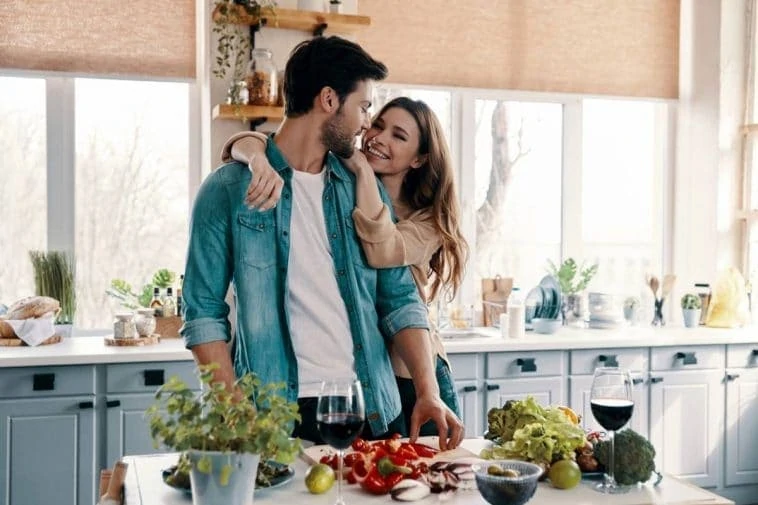 Jeune couple exprimant son amour à travers des surprises pour son homme dans la cuisine.