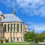 Une grande cathédrale avec une grande pelouse et des arbres.