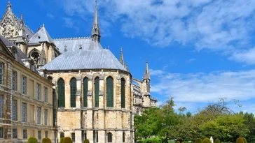 Une grande cathédrale avec une grande pelouse et des arbres.