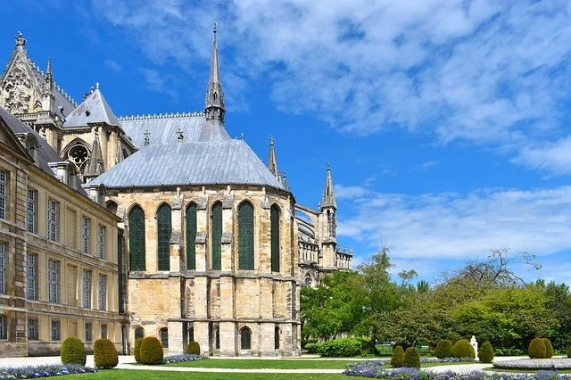 Une grande cathédrale avec une grande pelouse et des arbres.