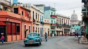 Une vieille voiture circulant dans une rue de la Havane.