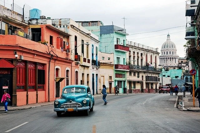 Une vieille voiture circulant dans une rue de la Havane.