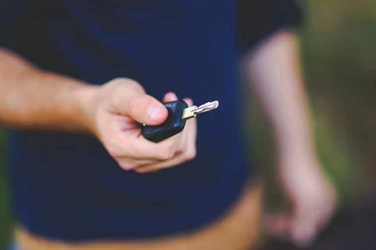 Un homme tenant une clé de voiture à la main se demande : J'ai perdu mon permis, que faire ?