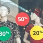 Mannequins devant une fenêtre avec une pancarte de vente.