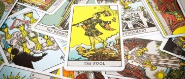 Les différentes catégories du tarot sont disposées en tas sur une table.