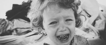 Une photo en noir et blanc d'une petite fille qui pleure.