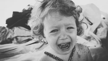 Une photo en noir et blanc d'une petite fille qui pleure.